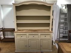 A two part painted pine kitchen dresser, the arched open top fitted with two shelves, the base