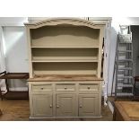 A two part painted pine kitchen dresser, the arched open top fitted with two shelves, the base