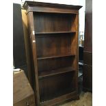 A hardwood upright open bookcase with moulded cornice, fitted four adjustable shelves, on bracket