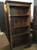 A hardwood upright open bookcase with moulded cornice, fitted four adjustable shelves, on bracket