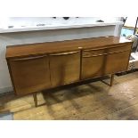 A 1960's teak sideboard, the rectangular top with two cupboard doors, enclosing a single shelf,