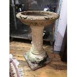 An ornate composition bird bath, the circular top with shallow bowl, supported on a single column