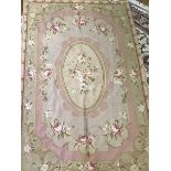 An Aubusson rug, the central panel with roses, on light coloured field, with rose and leaf