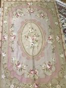 An Aubusson rug, the central panel with roses, on light coloured field, with rose and leaf