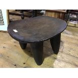 A carved African hardwood Senufo (Ivory Coast) stool/low table, the oval top on four substantial