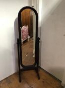 A 1970's/80's mahogany framed cheval mirror, the rectangular mirror with arched top, on trestle