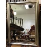 An Edwardian style wall mirror in moulded silver finish frame, and with bevelled plate (94cm x