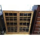 A 1930s Heals of London glazed walnut bookcase, the rectangular top above two astragal glazed