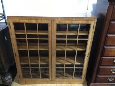 A 1930s Heals of London glazed walnut bookcase, the rectangular top above two astragal glazed