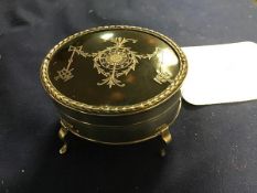 An oval silver and tortoiseshell jewellery box, inset Pique to top, on a plain body, raised on