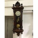 A Vienna walnut cased wall clock, the shaped and carved pediment above a moulded top, with glazed