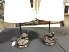 A pair of bronzed composition table lamps, the naturalistic moulded circular bases with perched game