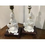 A pair of mid 20thc. blanc de chine table lamps in the form of seated courtesans, mounted on