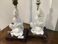 A pair of mid 20thc. blanc de chine table lamps in the form of seated courtesans, mounted on