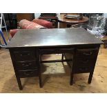 A 1930s oak twin pedestal kneehole desk, the rectangular top above central frieze drawer, flanked by