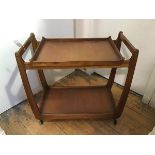 A 1960's teak hostess trolley, the top with lift off tray top, on plain shaped supports, undertier