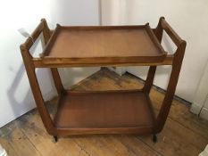 A 1960's teak hostess trolley, the top with lift off tray top, on plain shaped supports, undertier