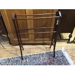An early 20thc mahogany four bar towel rail, on square supports with shaped feet