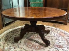 A 19thc. figured walnut breakfast table, the oval top with moulded edge and plain frieze on carved