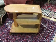 An Art Deco three tier oak side table with bentwood end support and fitted with two open shelves. (