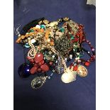 A bag containing a mixed lot of bead necklaces, pendants etc., including a millefiore style pendant,