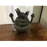 A Chinese bronze censer of circular bellied form, the cover mounted with kylin finial, the body with