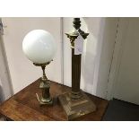 An early 20thc Corinthian column brass table lamp, converted from paraffin, together with another