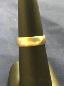 An 18ct gold broad wedding band (3.9g)