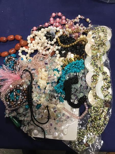 A bag containing a mixed lot of bead necklaces including glass, mother of pearl, polished stone,