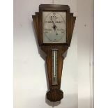 A 1930s oak cased Art Deco barometer, the fan shaped top enclosing a rectangular silvered dial above