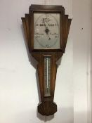 A 1930s oak cased Art Deco barometer, the fan shaped top enclosing a rectangular silvered dial above