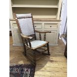 A Victorian elm rocking chair, with upholstered back and seat, with shaped arms, on turned