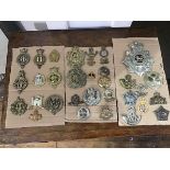 A collection of British military cap badges including a Royal Lancaster First Volunteer Battalion
