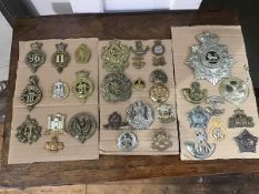 A collection of British military cap badges including a Royal Lancaster First Volunteer Battalion