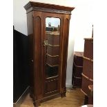 An early 20thc mahogany single door wardrobe, the dentil cornice above a retwork frieze and a single