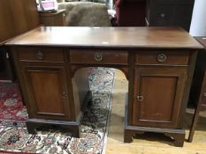An Edwardian mahogany twin pedestal kneehole desk, the crossbanded rectangular top with moulded