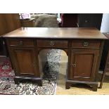 An Edwardian mahogany twin pedestal kneehole desk, the crossbanded rectangular top with moulded