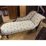 A late Victorian walnut chaise longue, the upholstered curved back, with moulded and carved top