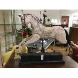 A Folk Art style treen carved and painted carnival horse, on steel rod and ebonised block base (h.