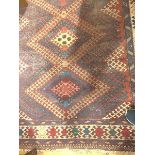 A Caucasian rug, Madderfield, with four ivory lozenges, within multiple ivory and blue guard