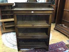 A 1920s bookcase, the ledgeback top with plain frieze above three shelves with retractable/