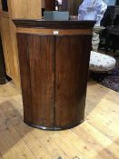 An early 19thc mahogany bow fronted corner cabinet, with painted interior fitted three shelves (