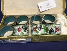 A set of eight Chinese Republic cloisonne napkin rings with floral and butterfly decoration, in