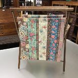 A 1920s/30s fabric sewing basket, raised on X framed supports, with turned handles (h. 47cm x 24cm)