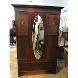 An Edwardian mahogany and inlaid wardrobe, the projecting cornice above a central bevelled glass
