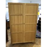 A Habitat Radius oak two door wardrobe, the panelled doors enclosing a single hanging rail with