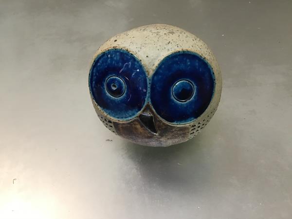 A pottery owl with blue enamelled eyes (h.8cm x 8cm x 6cm)