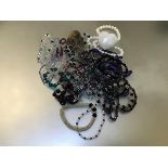 An assortment of costume jewellery including quartz and rose quartz bracelets, bead necklaces,
