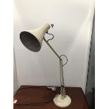 A white enamelled anglepoise lamp with trumpet shaped diffuser and adjustable stand, raised on a