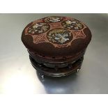 A Victorian walnut footstool with embroidered and bead work top, with spindle turned frieze,